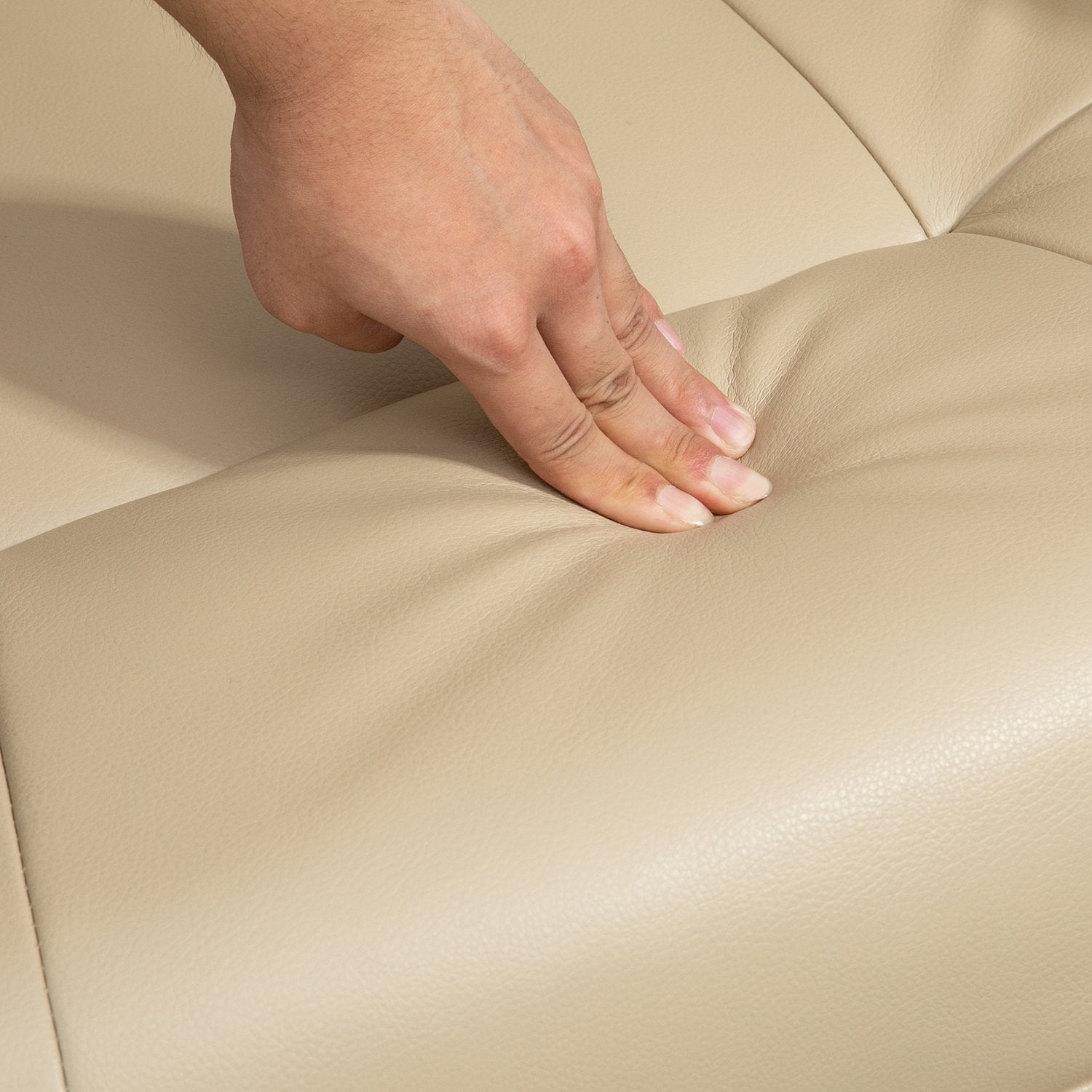 Gräddvit fåtölj i konstläder med fotstöd