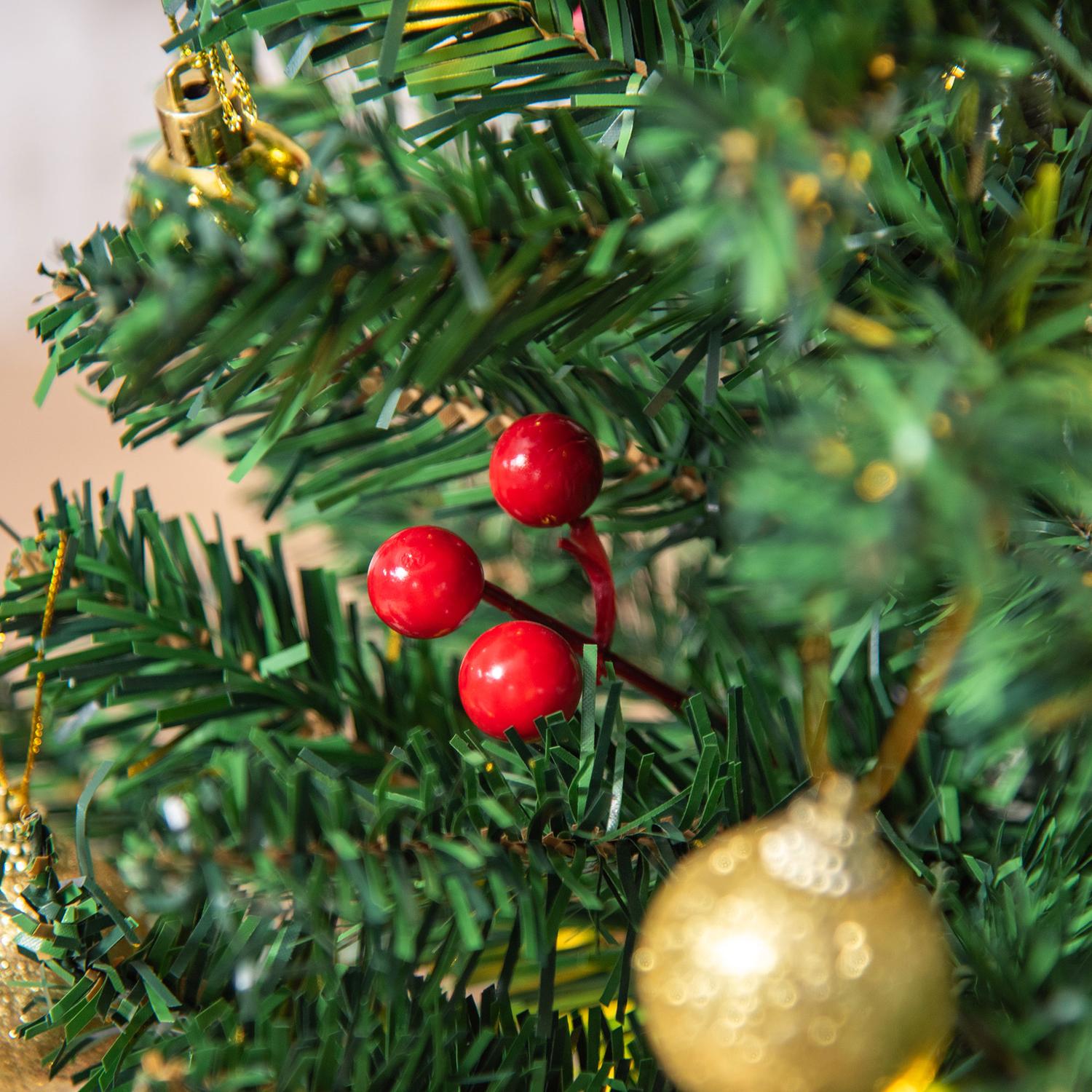 Liten grön julgran med LED-lampor och bär